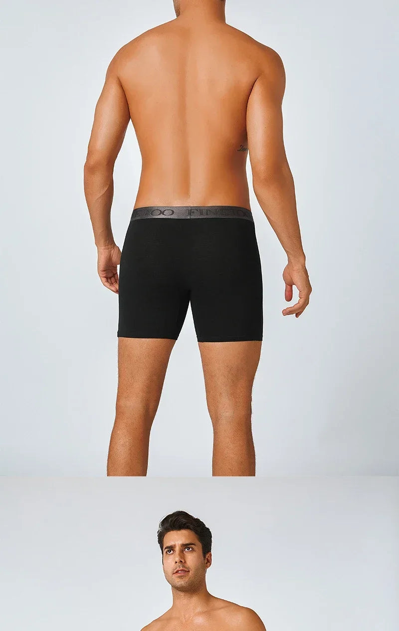 Man wearing black boxer briefs on a plain background